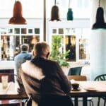 man in chair with table beside coffee