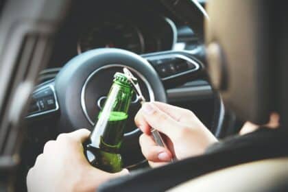 Person Opening Bottle on Car