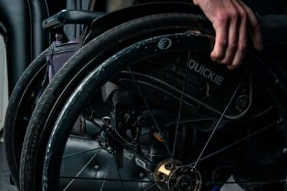 a person in a wheel chair with their hand on the wheel