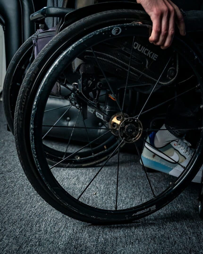 a person in a wheel chair with their hand on the wheel